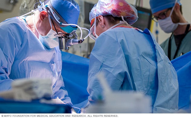 یک جراح و تیم جراحی در حین جراحی.